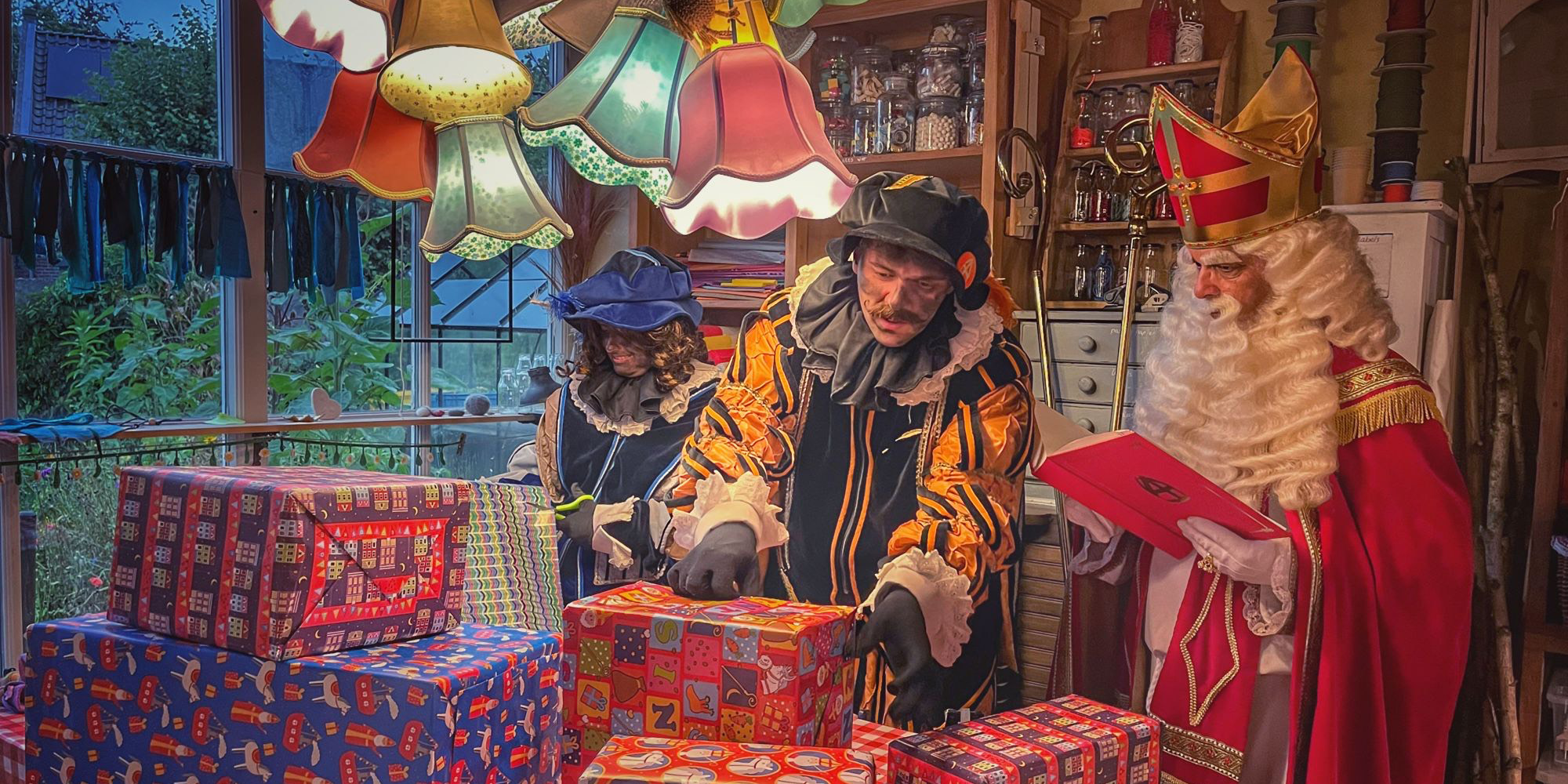 Sinten en Pieten bij een tafel vol pakjes